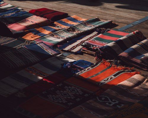 Rows of handwoven ikat cloth in deep reds and indigo