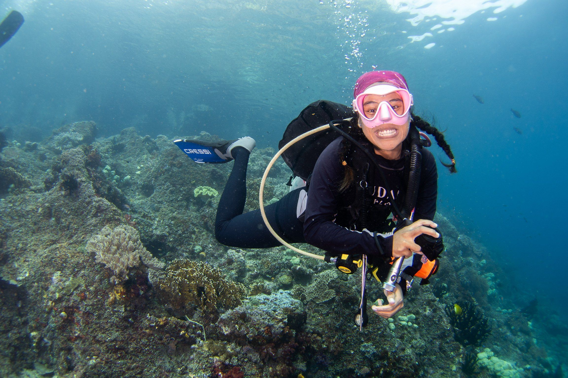 Diver smiling at the camera over a reef