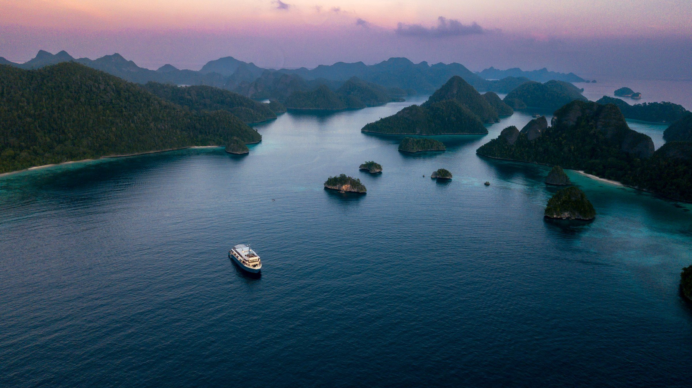 Boat among karst islands at dusk